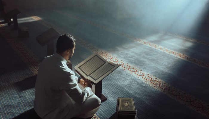 Young Muslim Guy Reading The Koran